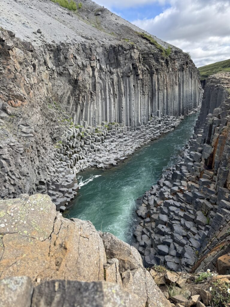 Towering basalt columns and turquoise glacial water in Stuðlagil Canyon, East Iceland