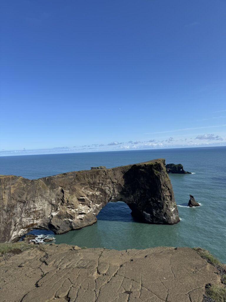 Massive natural stone arch and lighthouse at Dyrholaey promontory on the South Coast of Iceland