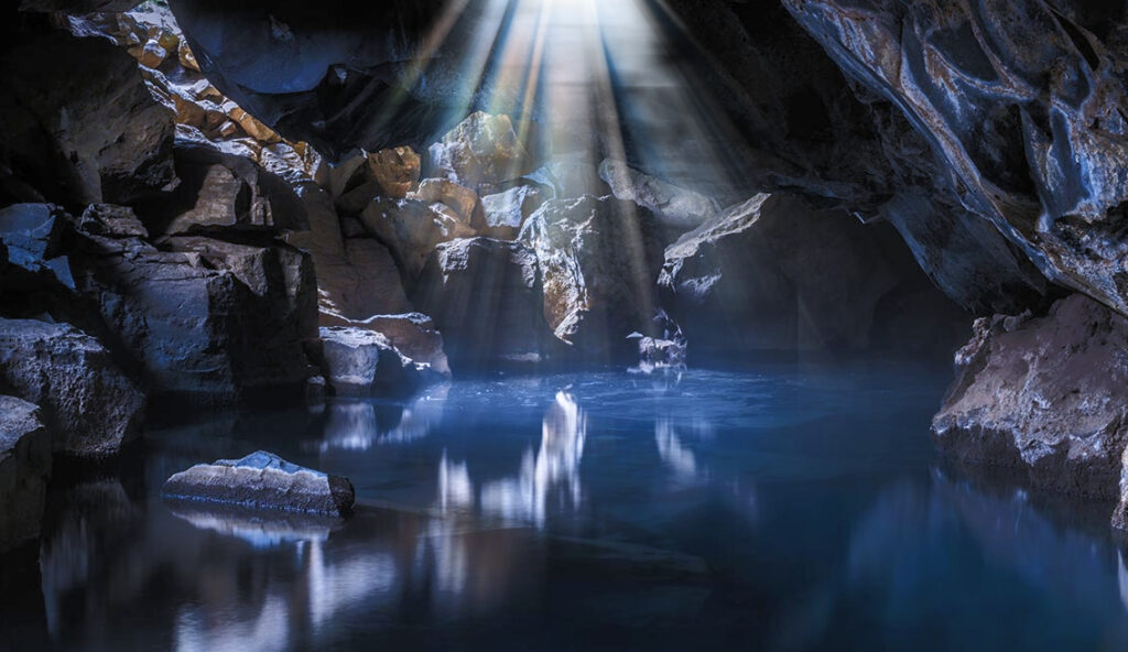 The interior of Grjótagjá lava cave in North Iceland with crystal-clear blue geothermal water
