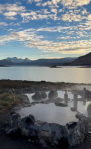 Natural geothermal pools at Hvammsvík Hot Springs on the edge of the Atlantic Ocean in Whale Fjord, Iceland.