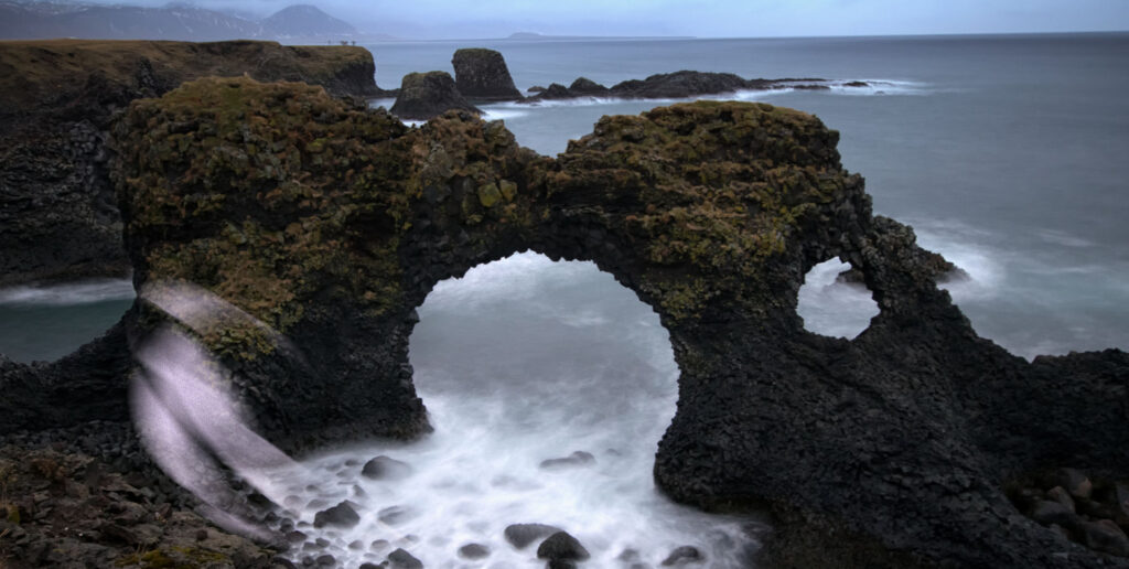 The dramatic stone arch Gatklettur and basalt cliffs along the Arnarstapi coastline on the Snaefellsnes Peninsula