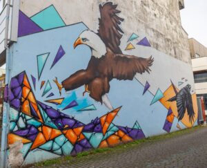 Close-up of a large-scale realistic eagle mural painted on a gray concrete building in downtown Reykjavik, Iceland.