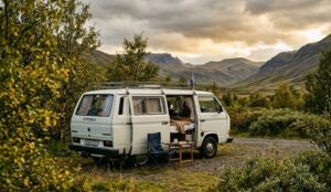 White campervan parked at Mosskógar campsite surrounded by birch trees near Reykjavík Iceland