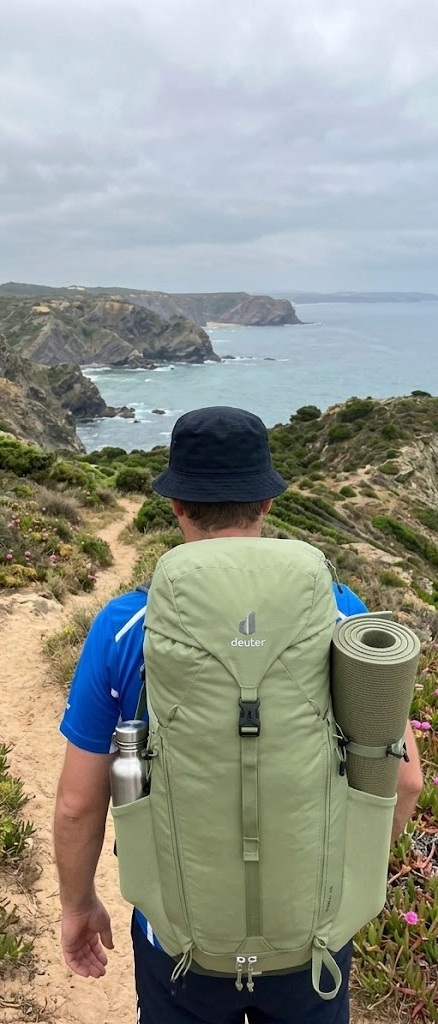 Hiker with backpack on the Fishermen's Trail coastal path overlooking the Atlantic Ocean Portugal