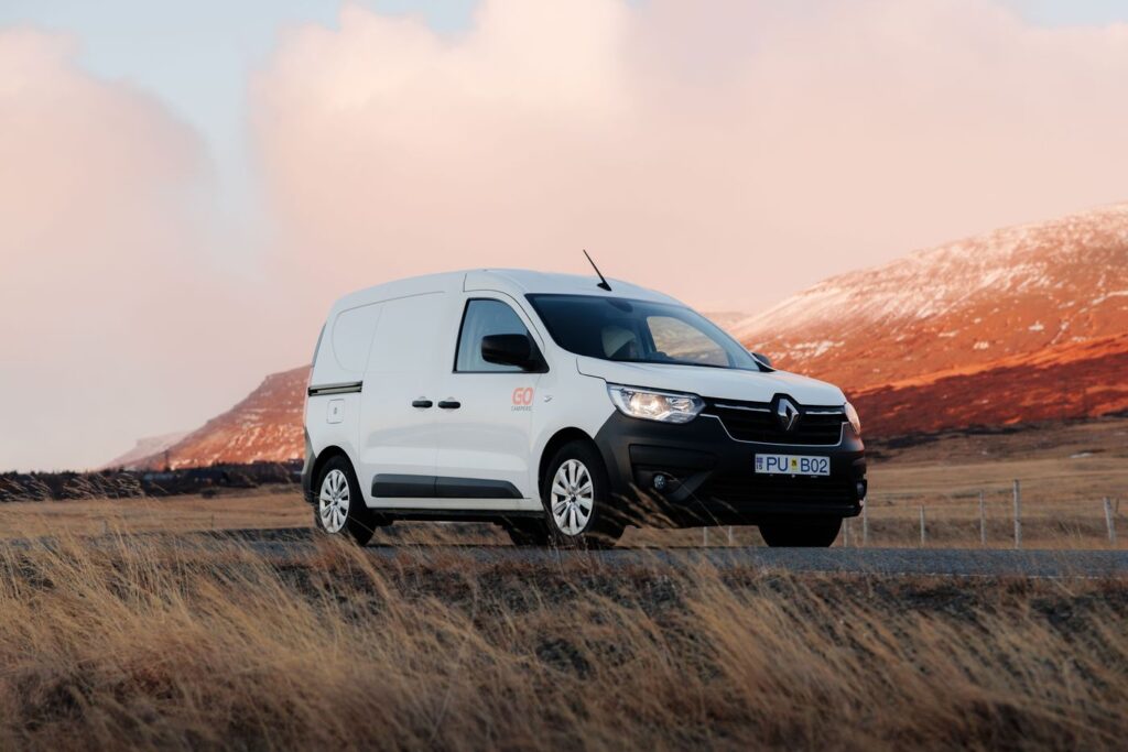 Go Campers campervan parked on a gravel road in Iceland with mountains behind