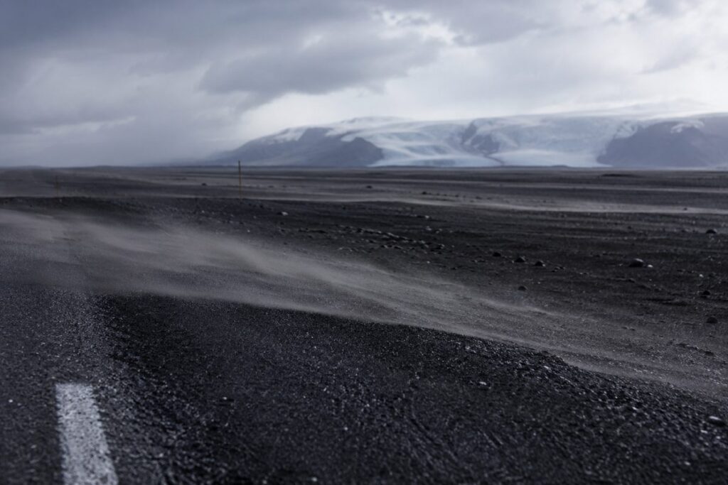 Wind-driven black sand blowing across the Ring Road on Iceland's south coast