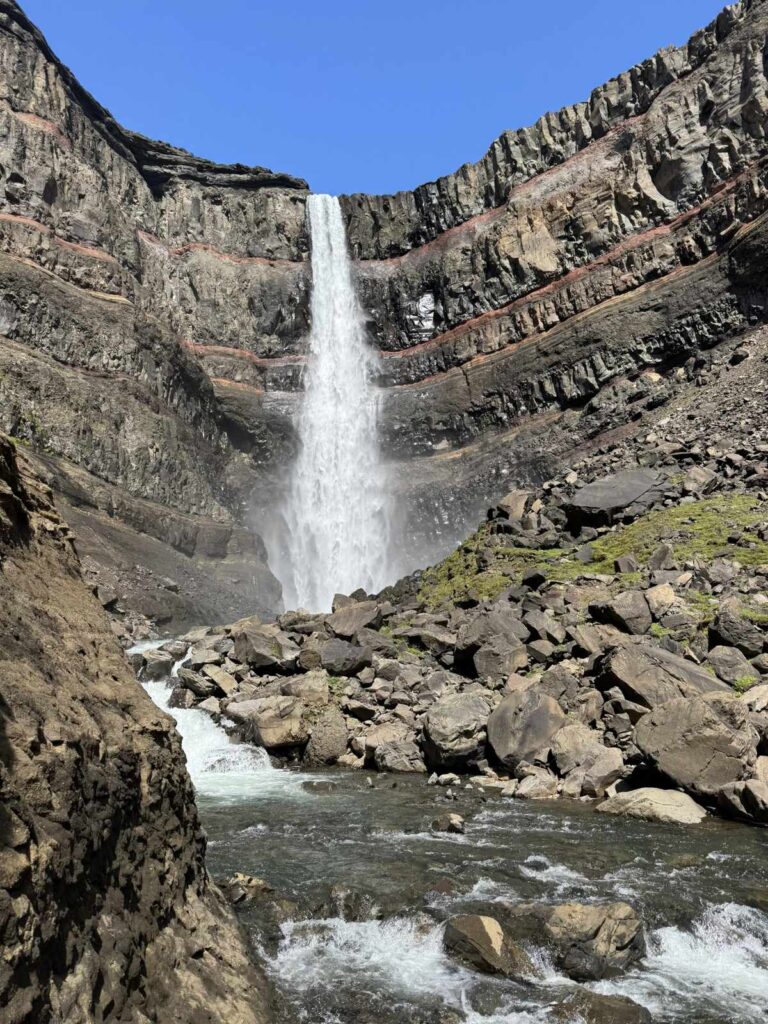 Hengifoss waterfall and its red clay layers seen from the end of the trail